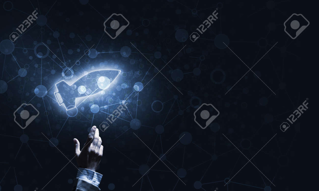 暗い背景に光のロケットを指している手をマンします の写真素材 画像素材 Image