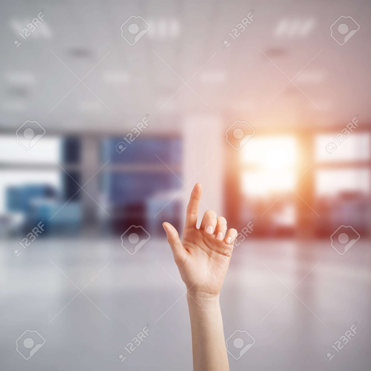 close of woman hand touching screen with finger and office at