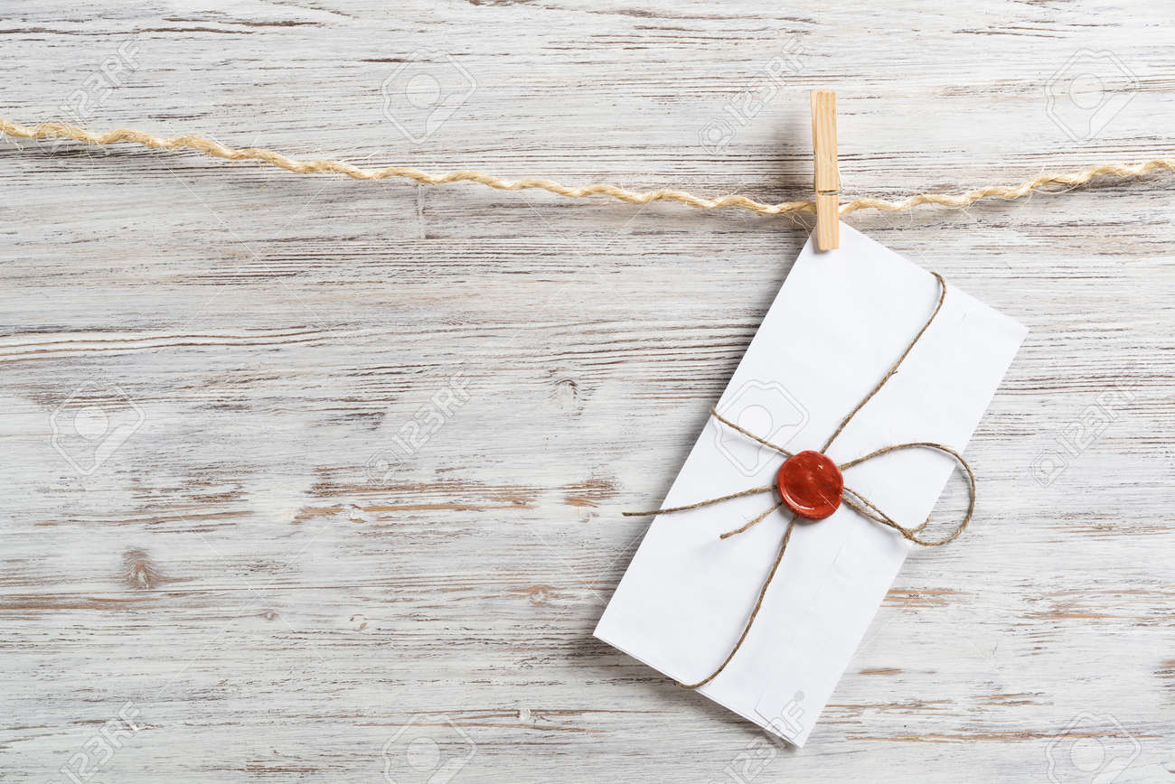 White envelope hanging on rope on wooden background. Twine rope with wooden clothespins. Letter envelope with wax seal stamp. Retro communication and correspondence. Delivery service layout - 136432408 White envelope hanging on rope on wooden background. Twine rope with wooden clothespins. Letter envelope with wax seal stamp. Retro communication and correspondence. Delivery service layout - 136432408