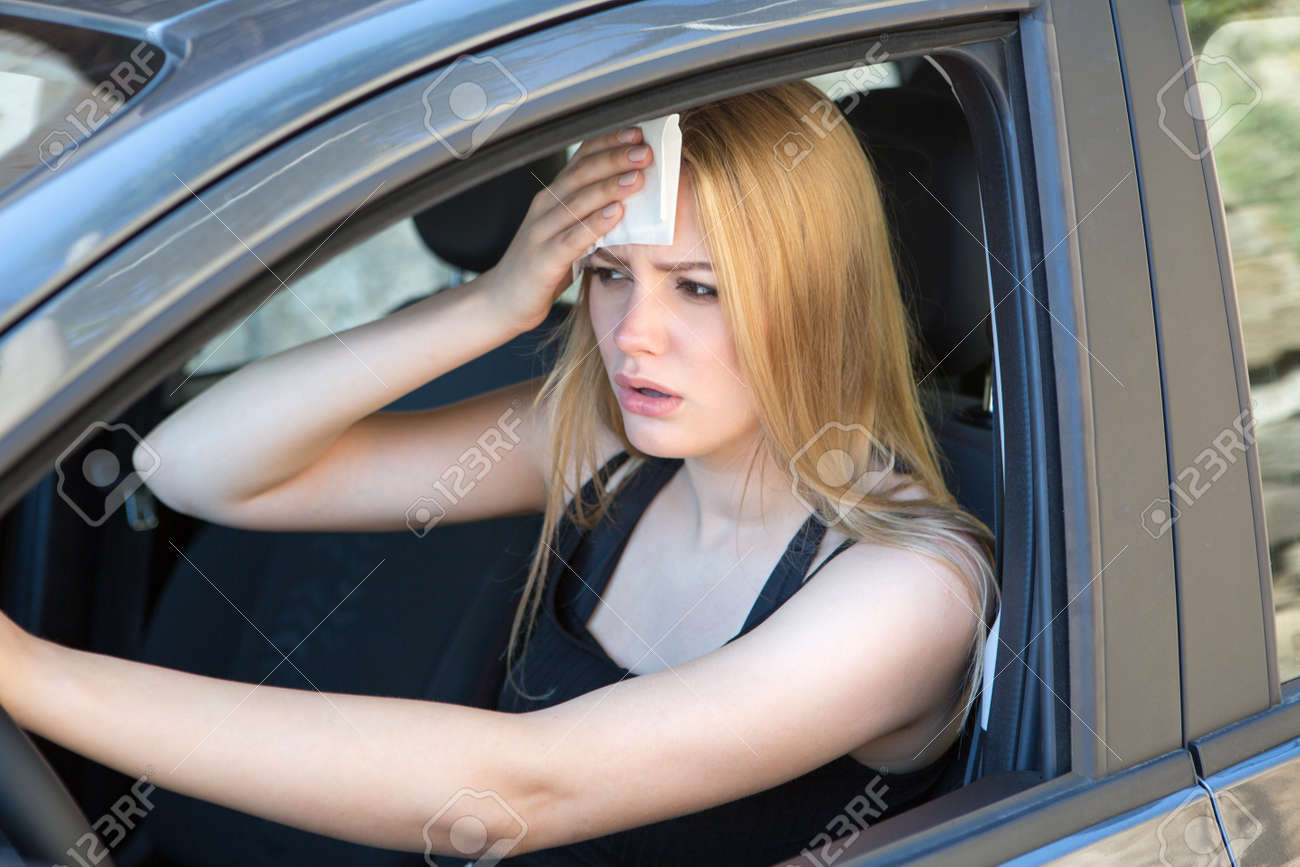 woman tired of heat in a car in summer - 103296100 woman tired of heat in a car in summer - 103296100