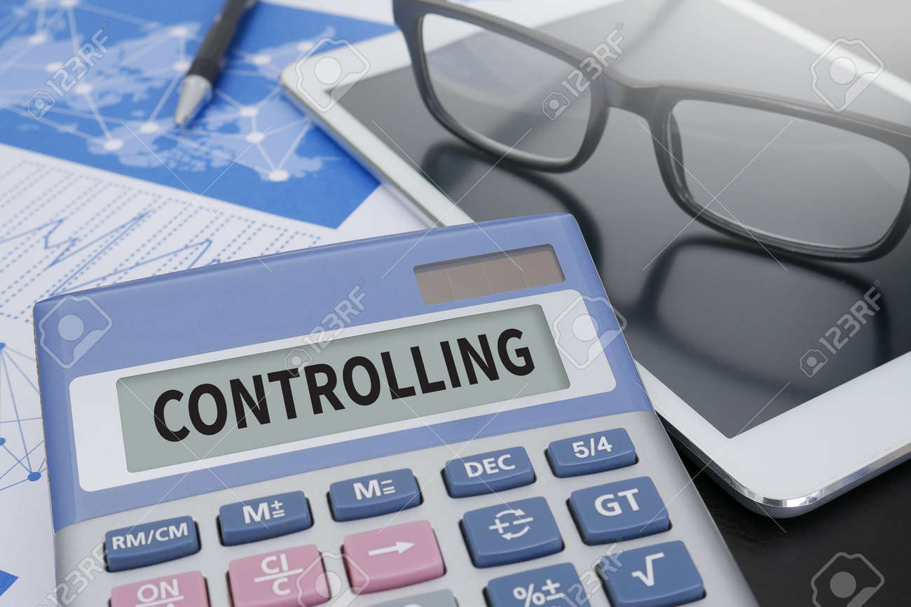 controlling calculator on table with office supplies stock photo