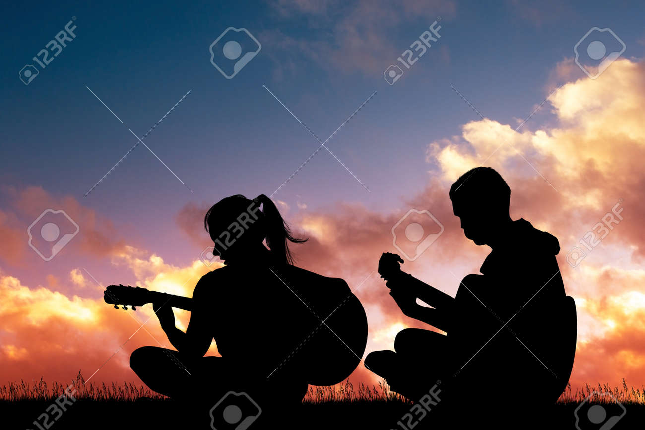 Boy And Girl Play Guitar At Sunset Stock Photo, Picture and Royalty Free  Image. Image 118835769.