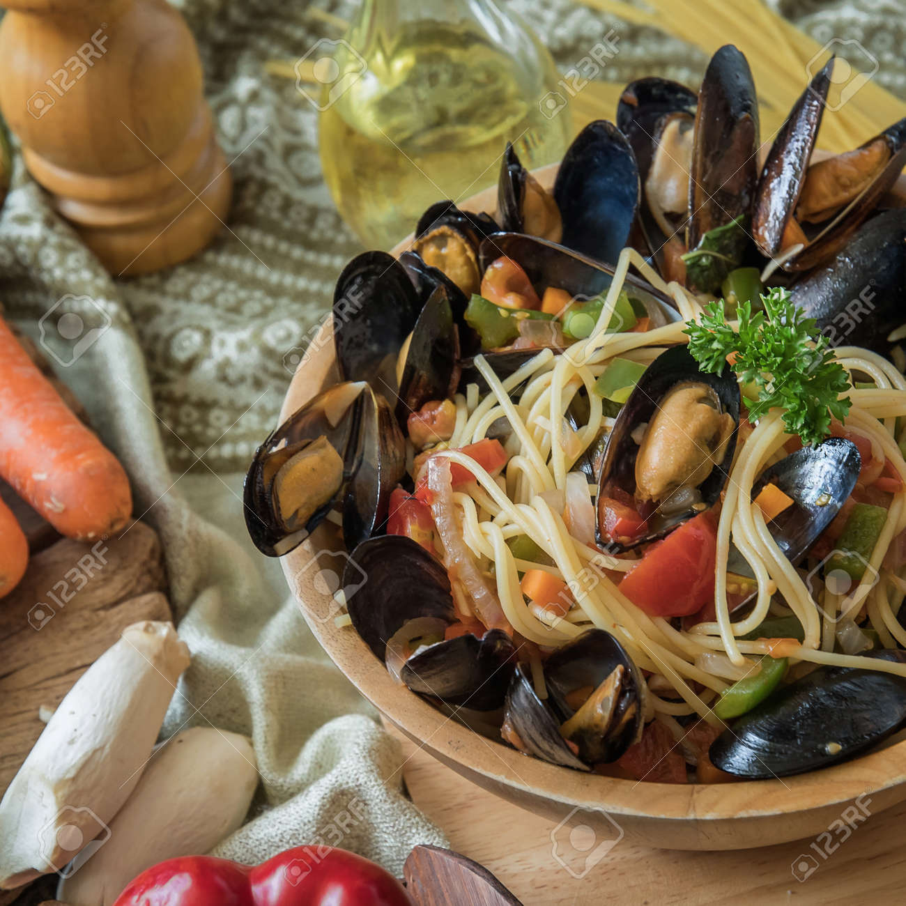 おいしいイタリアのスパゲティ ムール貝 シーフード 新鮮なスパゲッティ パスタ イタリアン パスタの夕食 スパゲッティバジルとトマト と木の板と合板の暗い背景の上にパスタを料理の食材のプレートで の写真素材 画像素材 Image
