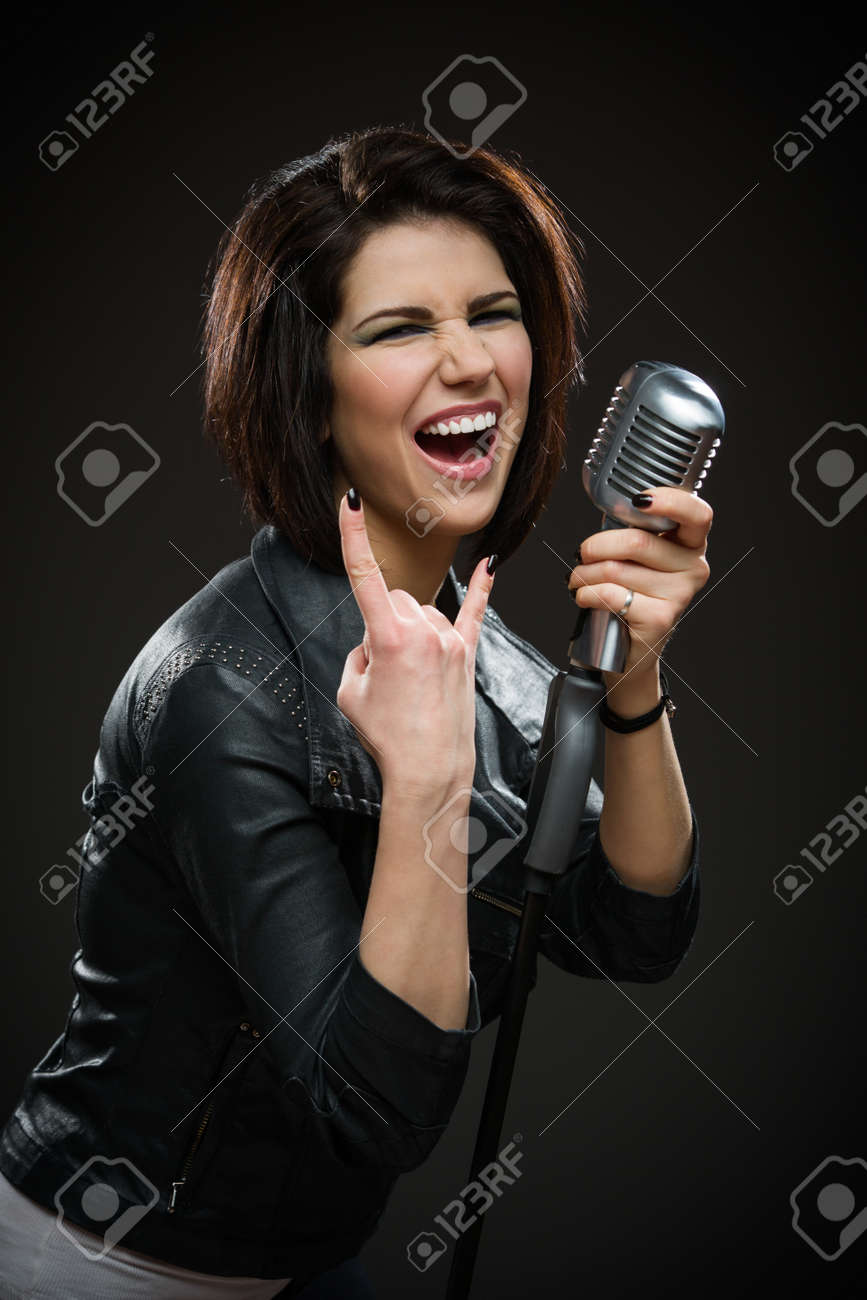 灰色の背景に黒のジャケットと維持するマイクを着て女性ロック歌手の半身像 音楽と Rave の概念 の写真素材 画像素材 Image