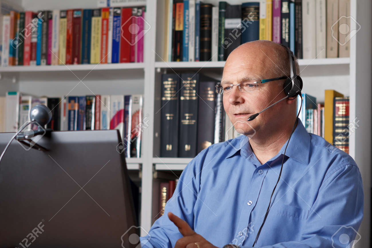 Man telephoning with computer, headset and webcam, copyspace - 25746095 Man telephoning with computer, headset and webcam, copyspace - 25746095