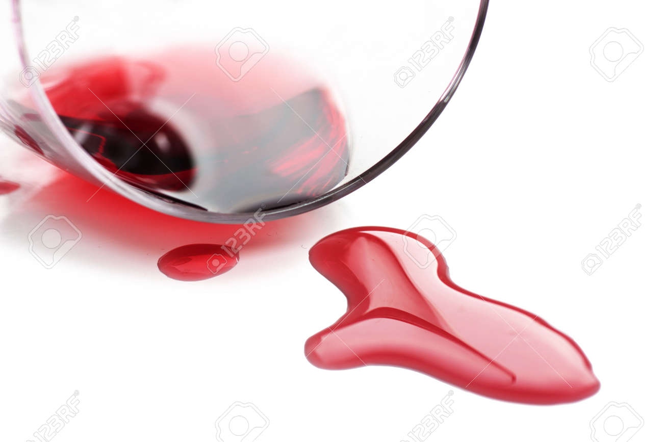 red wine spilled from glass over white background stock photo