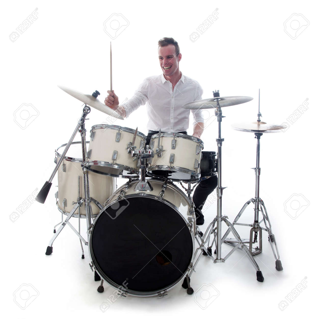 white drummer behind drum set wears white shirt and plays the