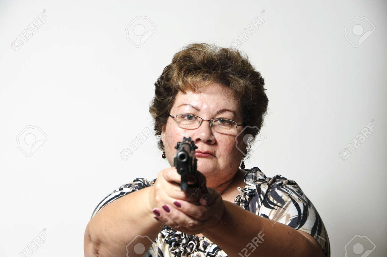 a 60 year old hispanic woman pointing a gun in self defense stock