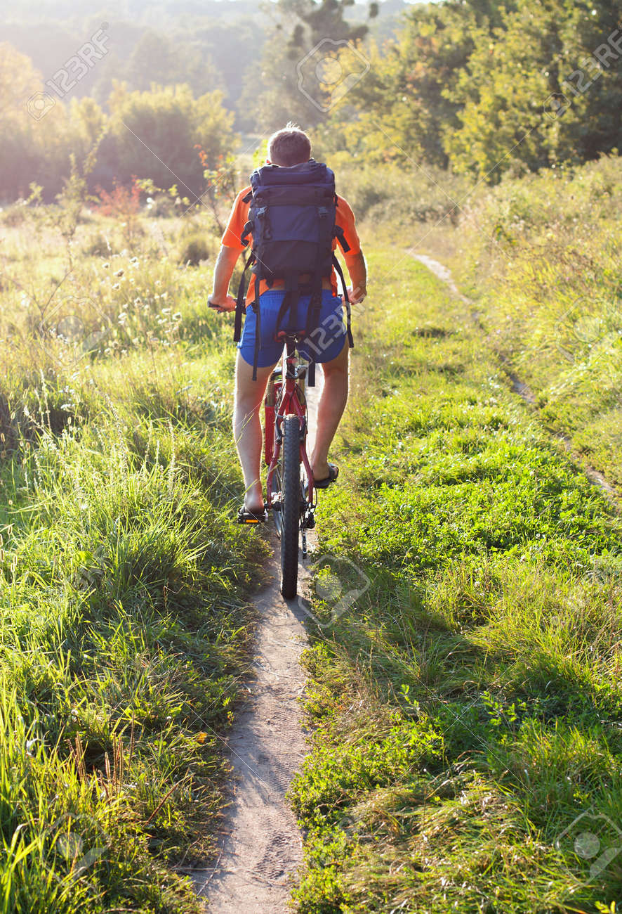 自転車乗ってすぐの距離に光線太陽に照らされた道。私たちに戻る の 