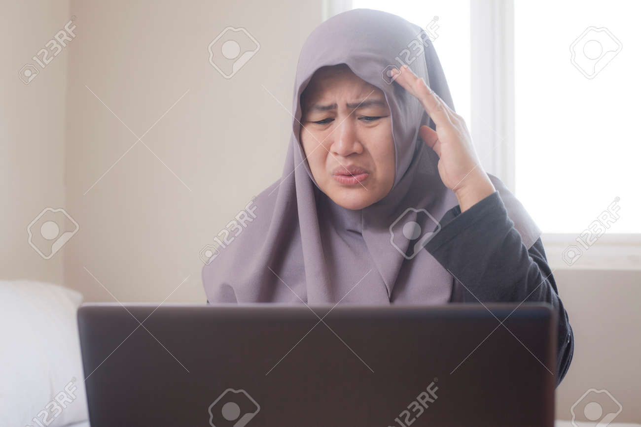 Sad muslim businesswoman crying expression to see bad financial report on laptop, loss in stock market concept - 121096717 Sad muslim businesswoman crying expression to see bad financial report on laptop, loss in stock market concept - 121096717