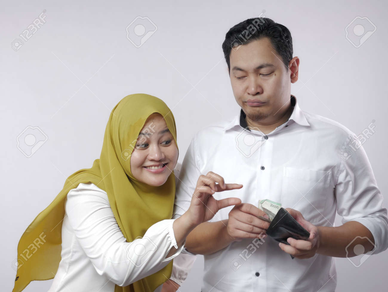 Portrait of muslim wife asks money to her husband, materialistic woman concept - 133176909 Portrait of muslim wife asks money to her husband, materialistic woman concept - 133176909