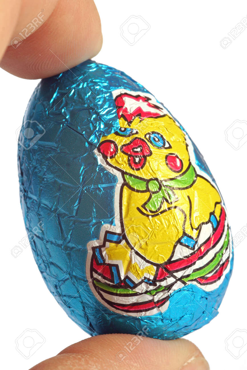 closeup chocolate Easter eggs between two fingers of the hand, and isolated on white background - 165942674 closeup chocolate Easter eggs between two fingers of the hand, and isolated on white background - 165942674
