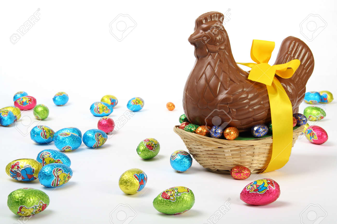 Chocolate Easter hen with yellow ribbon and bow, presented with colorful decorative eggs, isolated on white background - 165942599 Chocolate Easter hen with yellow ribbon and bow, presented with colorful decorative eggs, isolated on white background - 165942599