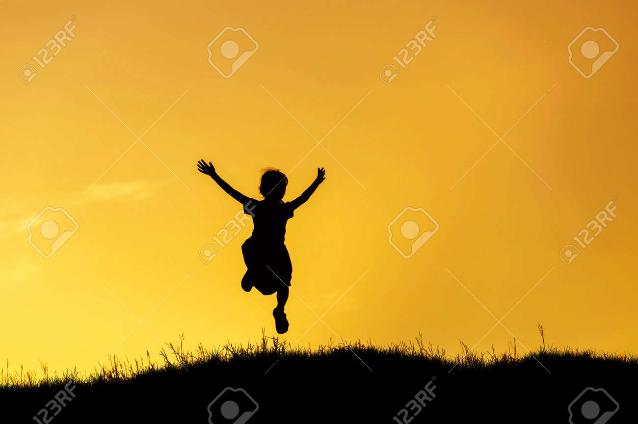 夕焼けの空にジャンプの幸せな女の子をシルエットします の写真素材 画像素材 Image