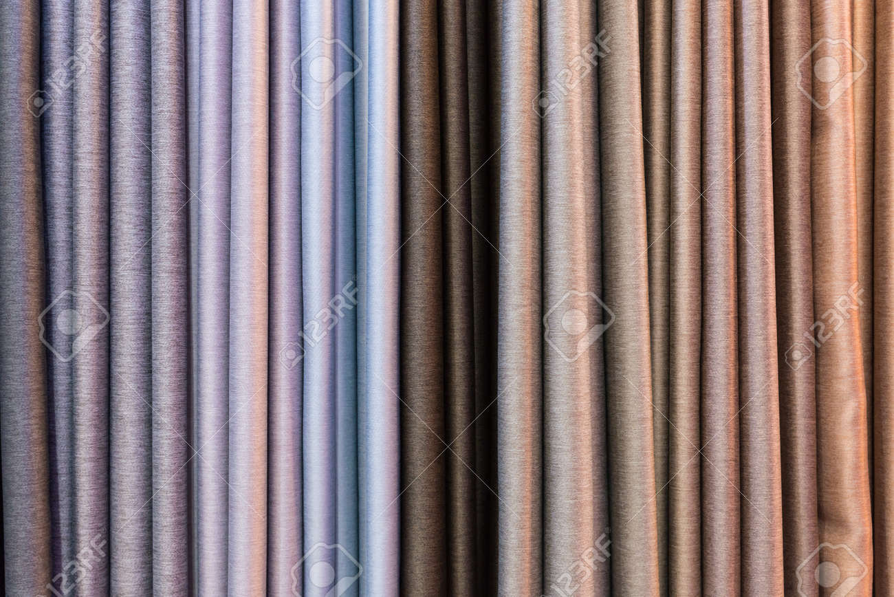 Chantillons de rideaux colorés suspendus à des cintres sur un rail dans un présentoir dans un magasin de détail Chantillons de rideaux colorés suspendus à des cintres sur un rail dans un présentoir dans un magasin de détail