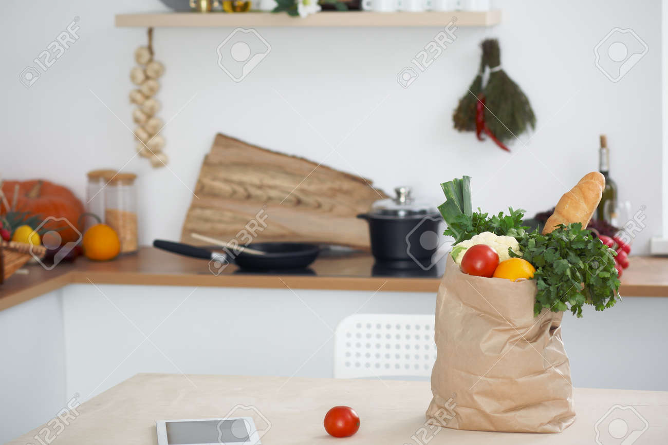 paper bag full of vegetables on the table in kitchen interiors