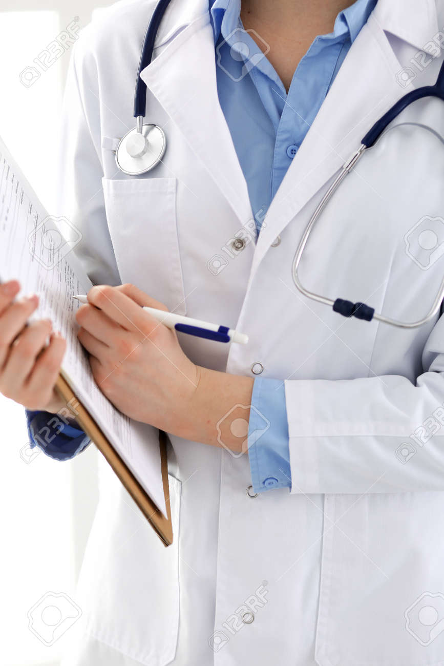 Female doctor using medical form on clipboard closeup. Physicianat work in hospital or clinic. Healthcare, insurance and medicine concept - 121621211 Female doctor using medical form on clipboard closeup. Physicianat work in hospital or clinic. Healthcare, insurance and medicine concept - 121621211