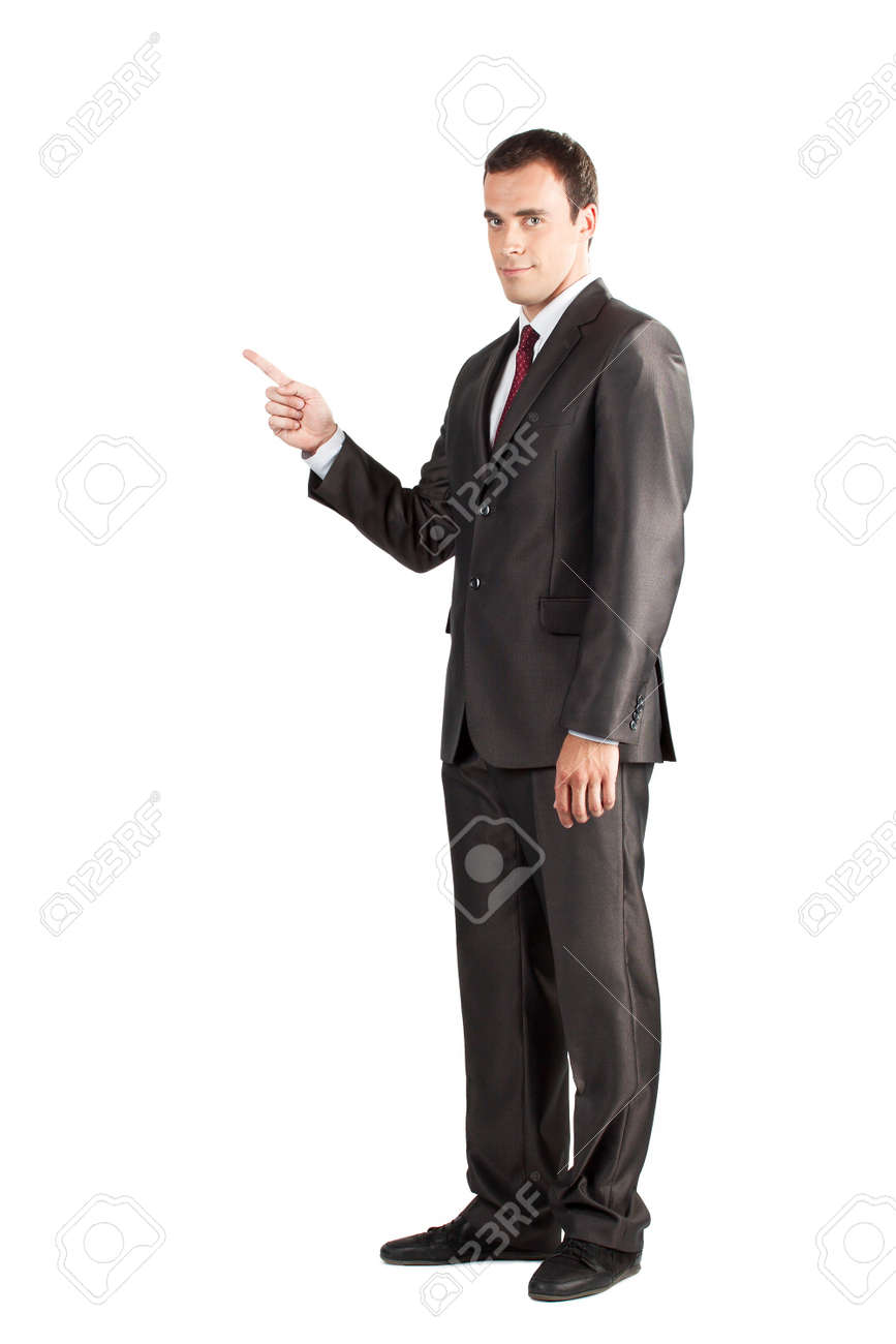 full length of young business man in suit pointing at copy space