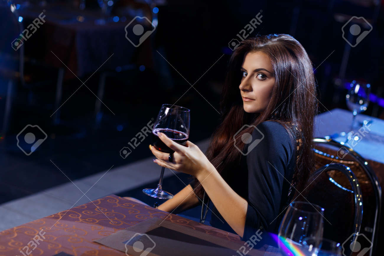 혼자 앉아 나이트 클럽에서 예쁜 여자는 와인 한 잔을 로열티 무료 사진, 그림, 이미지 그리고 스톡포토그래피. Image 38273009