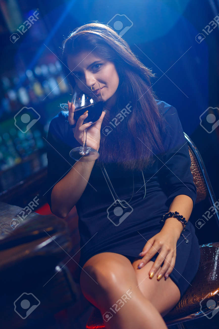 혼자 앉아 나이트 클럽에서 예쁜 여자가 와인 한 잔을 가지고 로열티 무료 사진, 그림, 이미지 그리고 스톡포토그래피. Image  80225662