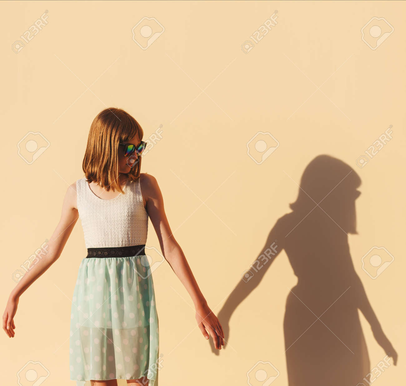 女の子は 壁に彼女の影の手を握る の写真素材 画像素材 Image