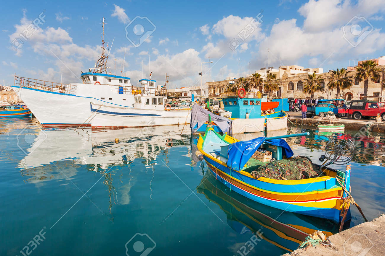 Mediterranean traditional colorful boats luzzu. Fisherman village in the south east of Malta. Early winter morning in Marsaxlokk, Malta. - 76425219 Mediterranean traditional colorful boats luzzu. Fisherman village in the south east of Malta. Early winter morning in Marsaxlokk, Malta. - 76425219
