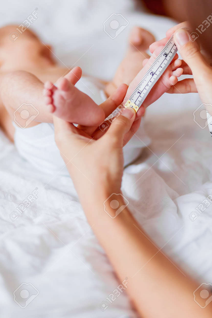 La Mere Tient Les Pieds Nus Du Nouveau Ne Et Mesure La Longueur Du Pied Matin Douillet A La Maison Banque D Images Et Photos Libres De Droits Image