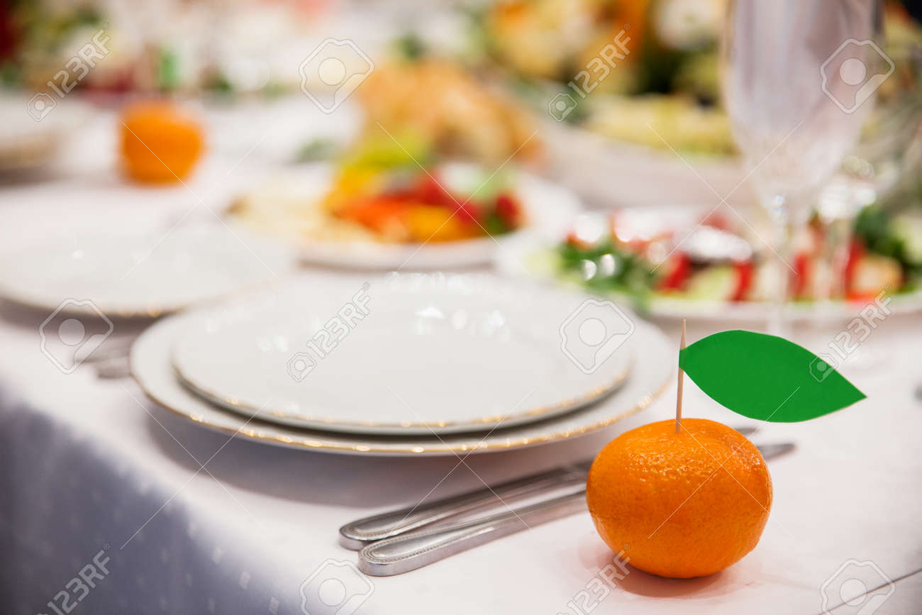 オレンジ スタイルで結婚式の宴会の設定のテーブル ゲストの名前を持つカードは みかんで立ち往生 の写真素材 画像素材 Image