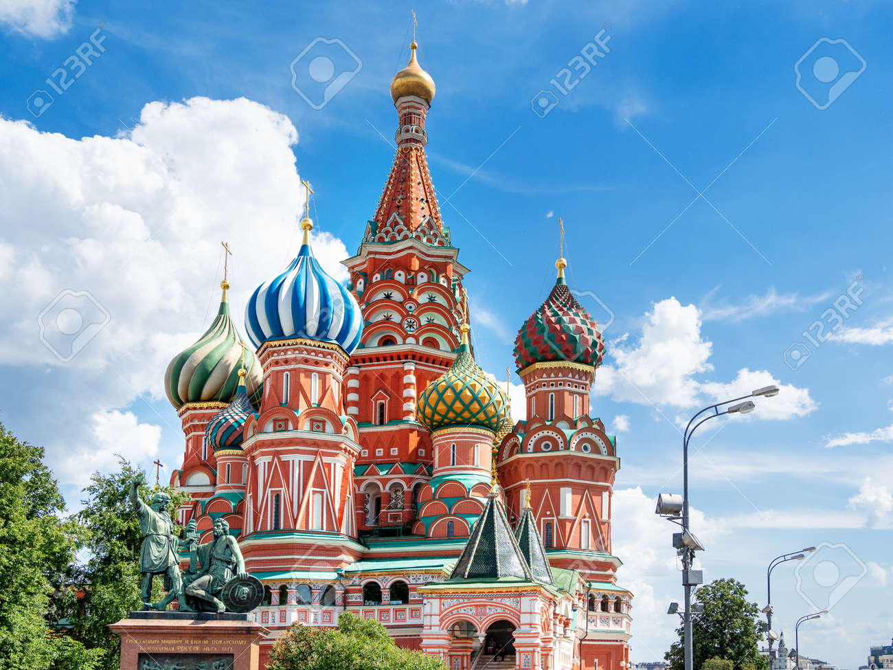 Domes of Saint Basil Cathedral on blue sky background. Monument to Minin and Pozharsky. Famous landmark of Moscow, Russia. - 159641004 Domes of Saint Basil Cathedral on blue sky background. Monument to Minin and Pozharsky. Famous landmark of Moscow, Russia. - 159641004