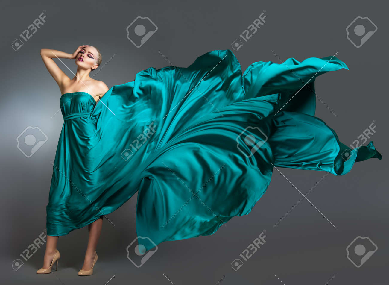 Woman in silk dress waving on wind. Flying and fluttering gown cloth over gray background Woman Dancing In Fashion Dress - 51333997 Woman in silk dress waving on wind. Flying and fluttering gown cloth over gray background Woman Dancing In Fashion Dress - 51333997