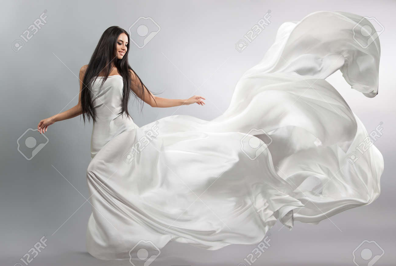 beautiful young girl in flying white dress. Flowing fabric. Light white cloth flying in the wind - 62374955 beautiful young girl in flying white dress. Flowing fabric. Light white cloth flying in the wind - 62374955
