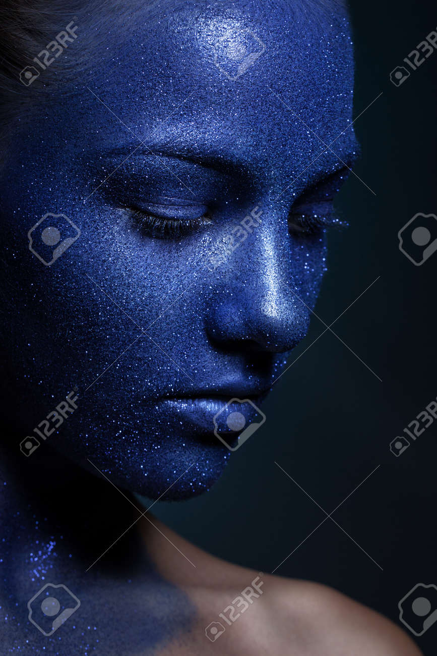 Portrait Of Young Beautiful Girl Face Painted With Blue Paint