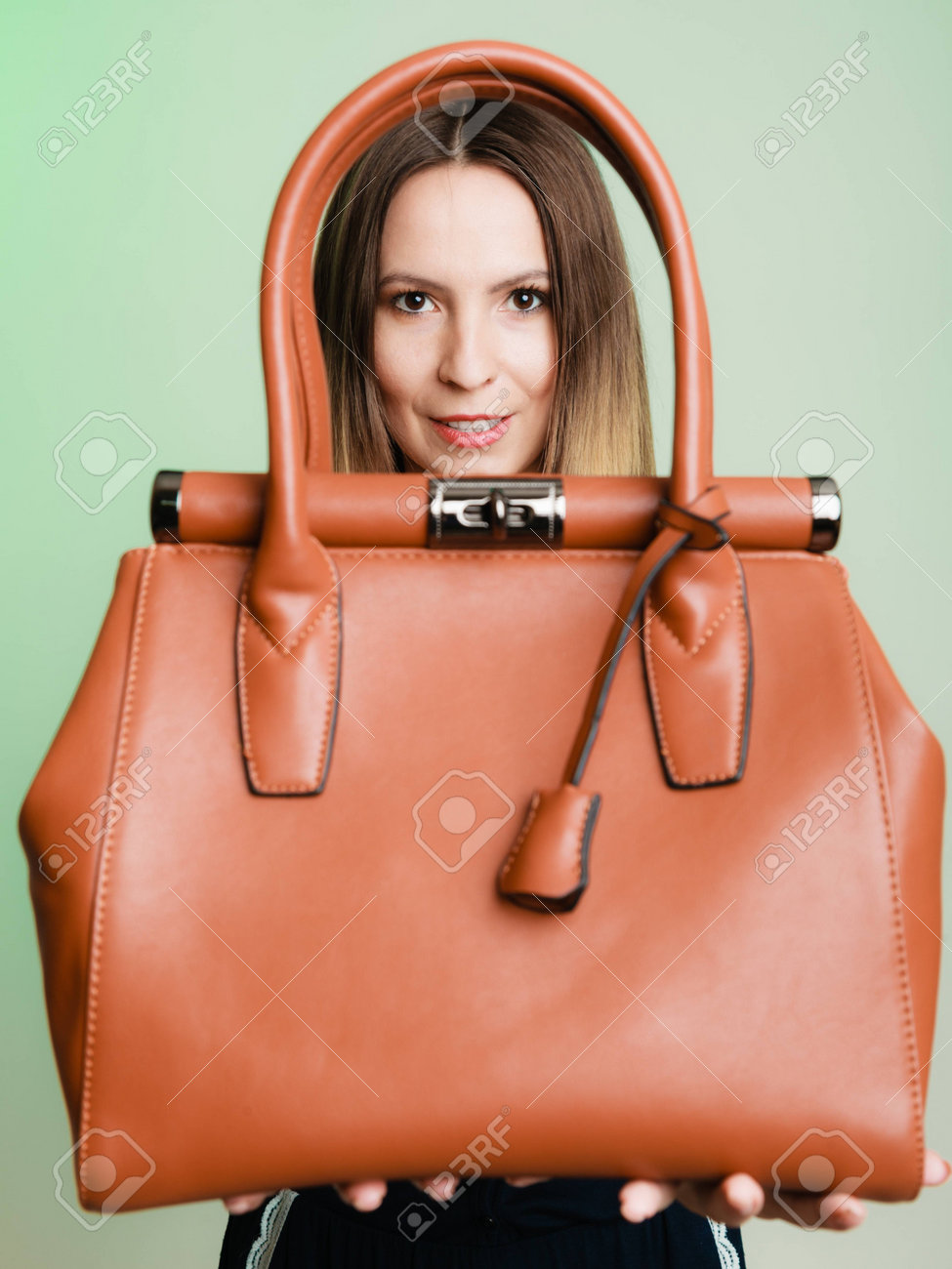 Traje elegante. Mujer chica de moda elegante con marrón del bolso del cuero en verde. La moda y la belleza femenina. Traje elegante. Mujer chica de moda elegante con marrón del bolso del cuero en verde. La moda y la belleza femenina.