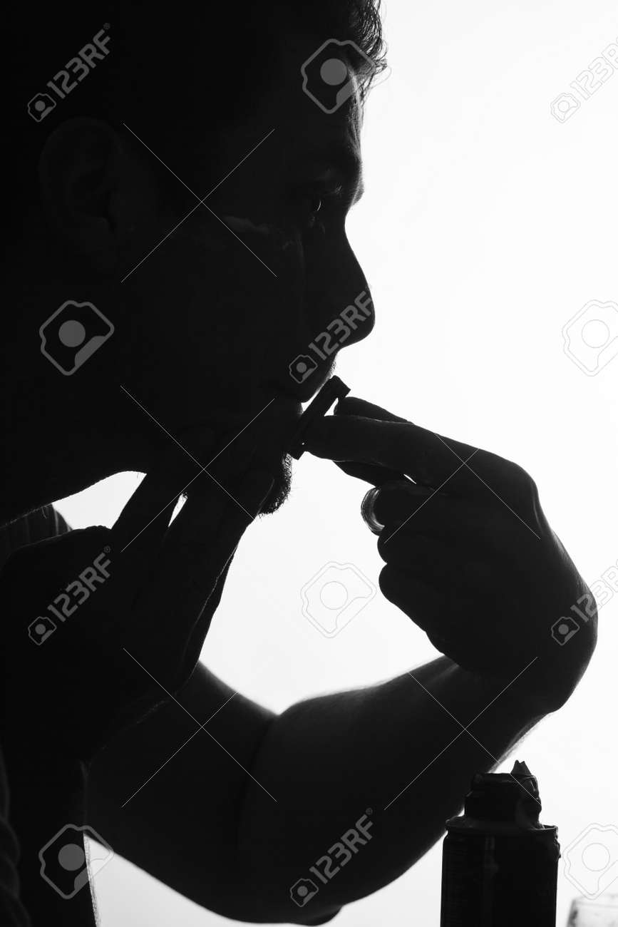 silhouette man shaving using razor with cream foam guy removing