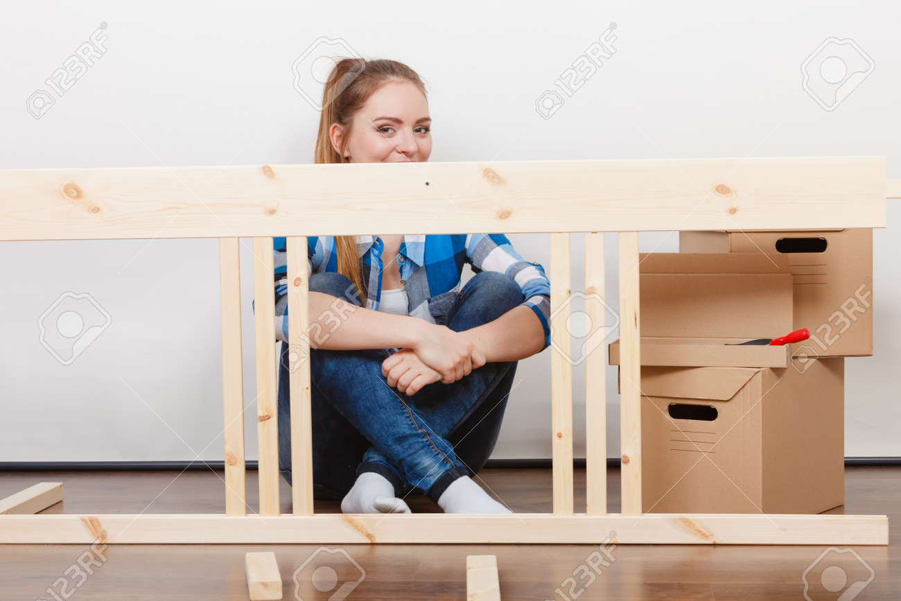 Femme se déplaçant dans montage de meubles au nouveau domicile. Jeune fille organisation intérieure appartement de maison et boîtes déballage. Femme se déplaçant dans montage de meubles au nouveau domicile. Jeune fille organisation intérieure appartement de maison et boîtes déballage.