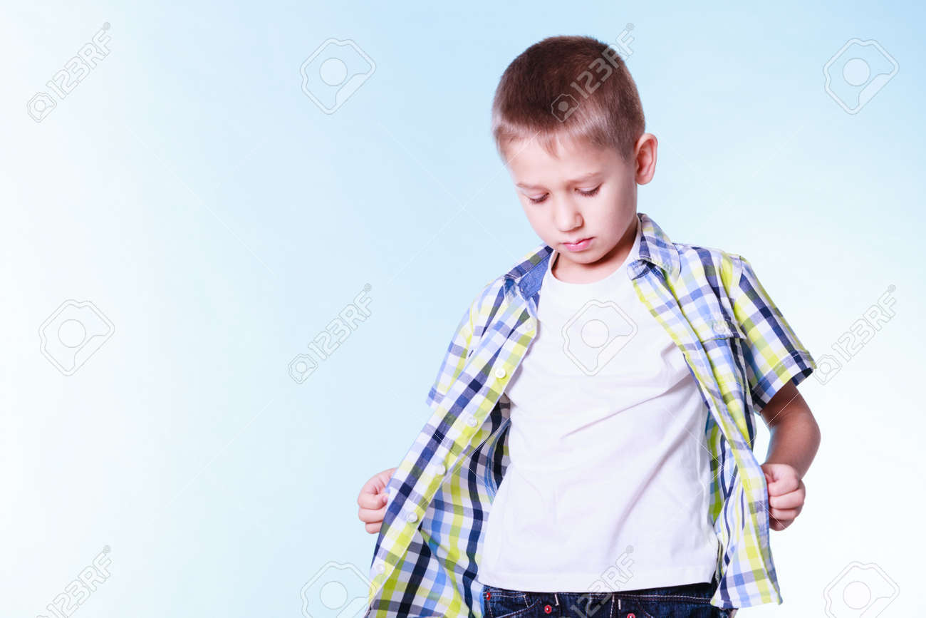 子供の独立のための衣服の継手です 男の子は立つだけでシャツを固定します 新しい服をしようとしている青年に備えます の写真素材 画像素材 Image