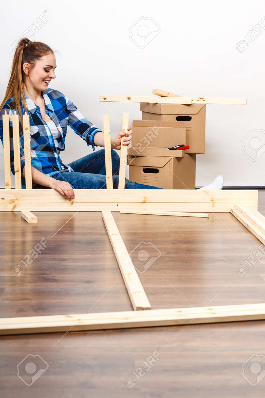 Femme se déplaçant dans montage de meubles au nouveau domicile. Jeune fille organisation intérieure appartement de maison et boîtes déballage. Femme se déplaçant dans montage de meubles au nouveau domicile. Jeune fille organisation intérieure appartement de maison et boîtes déballage.