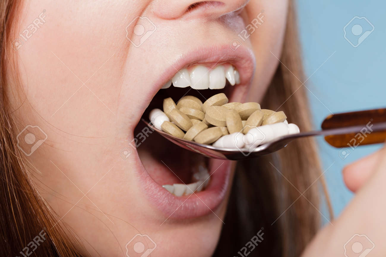 woman taking pills girl female eating stack of tablets drug