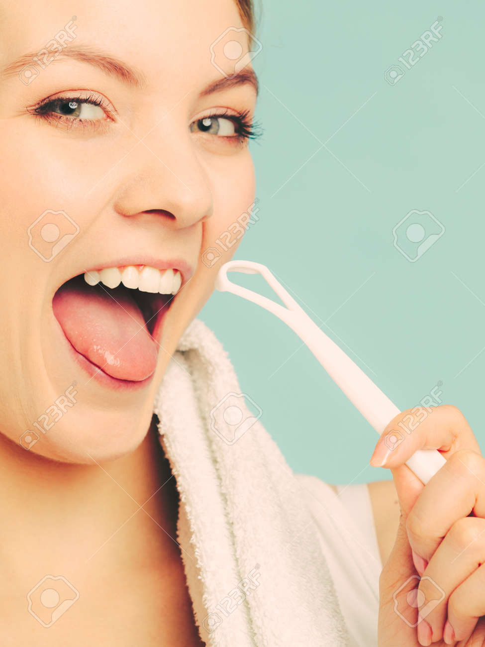 舌クリーナーでかなり若い女の子 幸せな女は 彼女の口腔内の歯の健康を気を洗浄します の写真素材 画像素材 Image