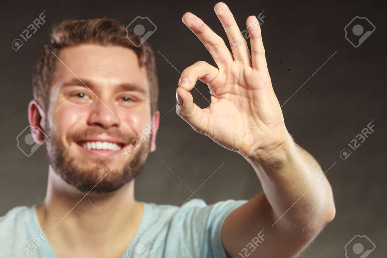 portrait of happy smiling handsome man guy giving ok okay sign