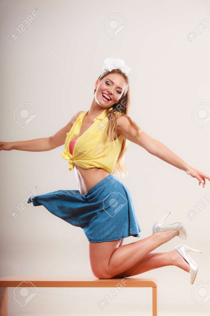 ヘアバンド弓 スカートとハイヒールを身に着けている女の子を魅惑的なかなりピンを誘います 魅力的な豪華な若いレトロ女性テーブルの上で踊っています の写真素材 画像素材 Image