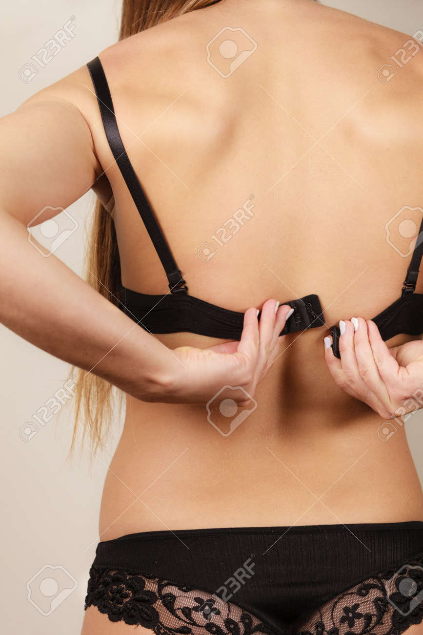 Vista Trasera De La Mujer Poniéndose O Quitándose La Ropa Interior Del Negro. Concepto De Bosom Atractiva Mujer Vestirse. Fotos, Retratos, Imágenes Y Fotografía De Archivo Libres De Derecho. Image 65443574.
