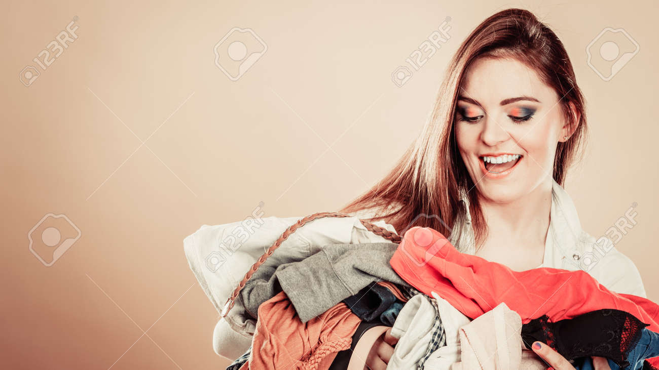 家庭洗濯での日常着用を決定します 若者は カラフルな服の女性保持する杭を興奮させた の写真素材 画像素材 Image