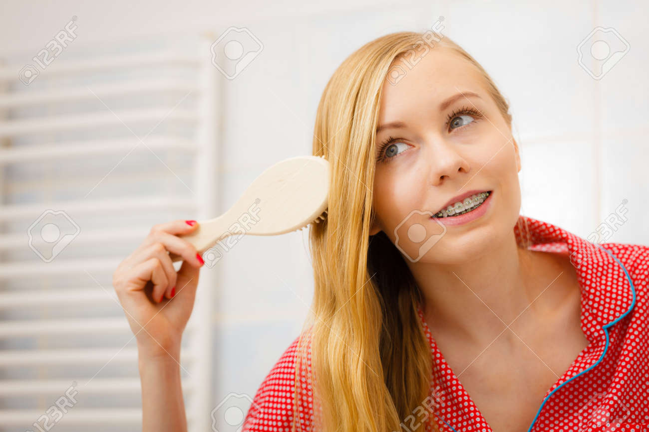 木製櫛付きのバスルームで彼女の長い滑らかな髪をブラッシングを梳く女たち 女の子の世話を彼女の髪型を更新します ヘアケアのコンセプトです の写真素材 画像素材 Image