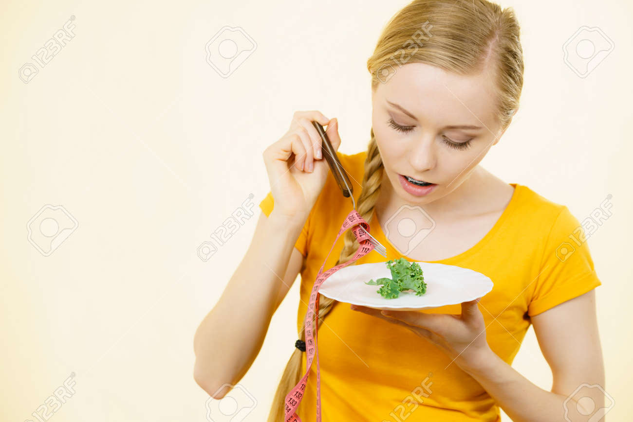 Sad Young Blonde Woman Dealing With Anorexia Nervosa Or Builimia Sad Young Blonde Woman Dealing With Anorexia Nervosa Or Builimia Having Small Green Vegetable On Plate