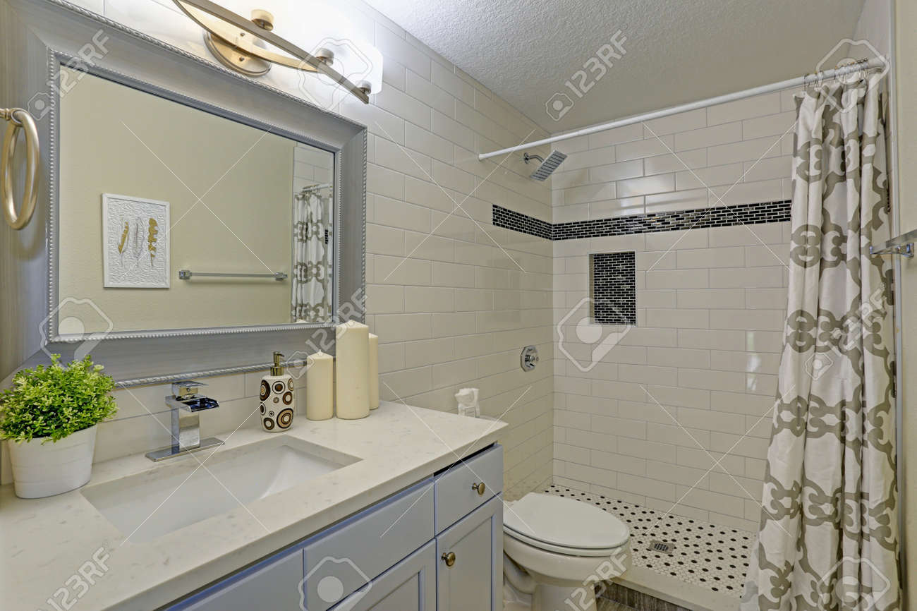 Freshly Renovated Bathroom Features Walk-in Shower Accented With White  Subway Tile Surround, Rain Shower Head, Tiled Shower Niche And Black And White  Shower Floor. Stock Photo, Picture and Royalty Free Image. Image, image size:1300x866