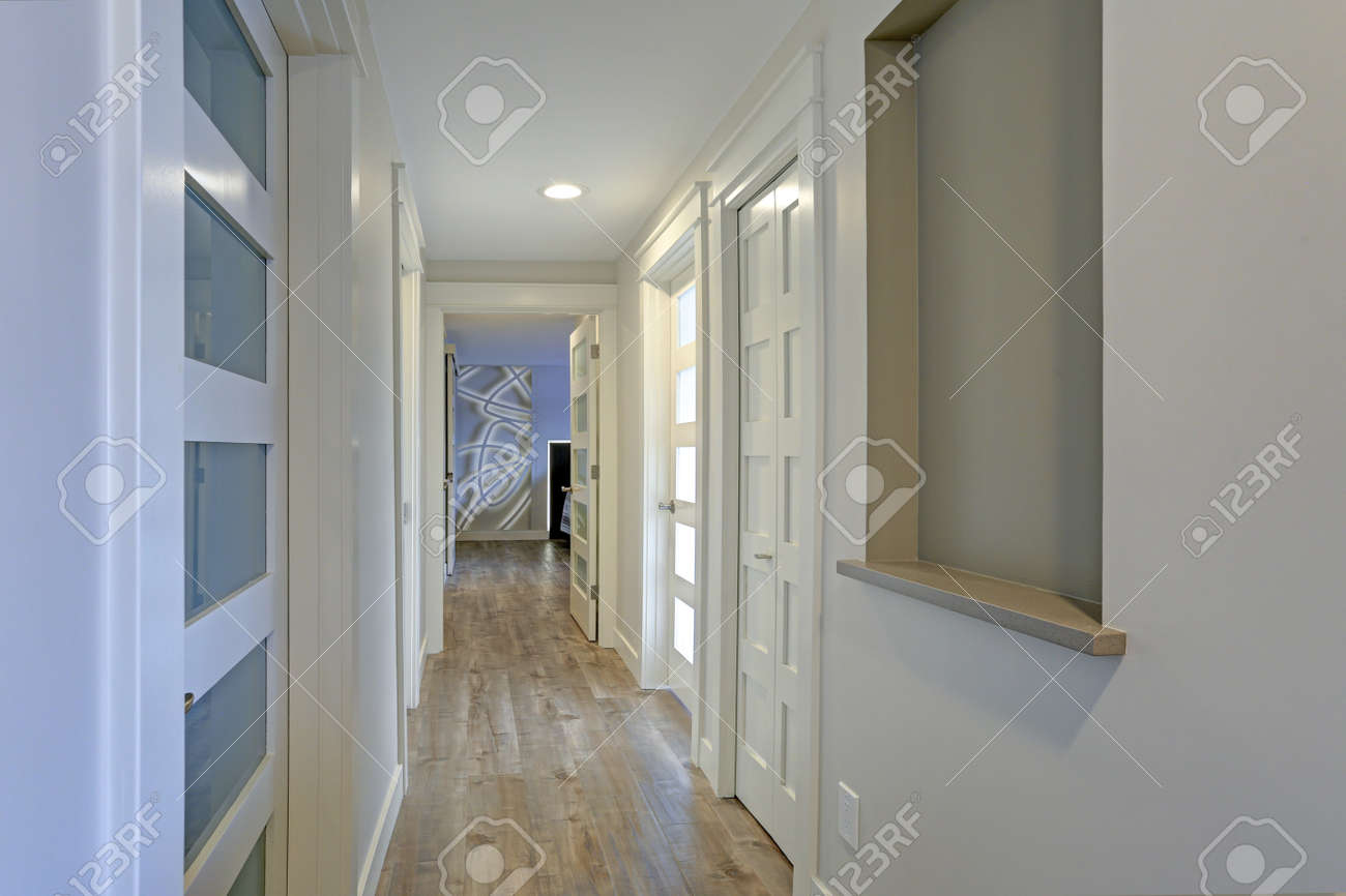 Beautiful Long Hallway Filled With White Doors Accented With