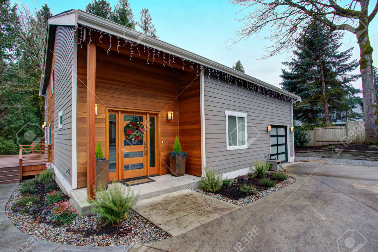 魅力的な新しく改装された家の外観 天然木のサイディングとグレーのサイディングは 美しい縁石の魅力を作成します の写真素材 画像素材 Image
