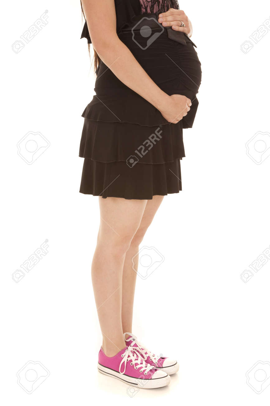 妊娠中の女性は 彼女のピンクの靴を履いている間彼女の腹にしがみついて の写真素材 画像素材 Image