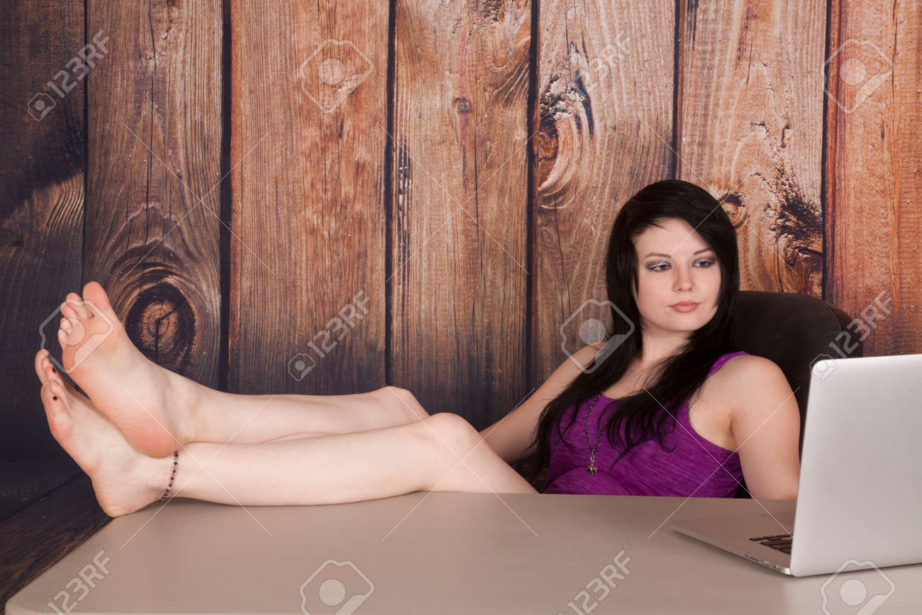 A Woman Sitting At Her Table Looking At Her Computer With Her Stock Photo Picture And Royalty Free Image Image 22421441 a woman sitting at her table looking at her computer with her